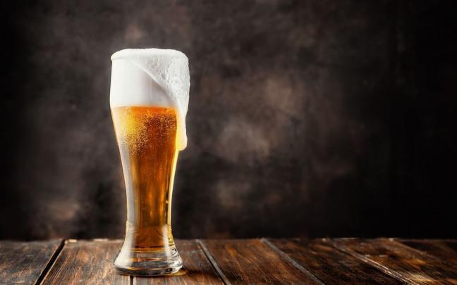 Espuma rebosante en un vaso con cerveza fresca. Espuma rebosante en un vaso con cerveza fresca.
