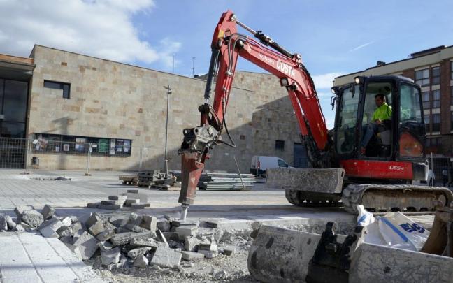 Una máquina rompe la explanada para los cimientos.