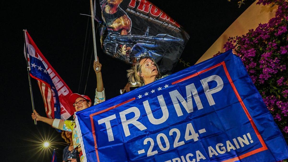 Una seguidora de Trump sujeta una pancarta en apoyo al expresidente ante su mansión de West Palm, Florida.