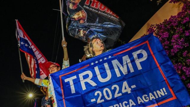 Una seguidora de Trump sujeta una pancarta en apoyo al expresidente ante su mansión de West Palm, Florida. Una seguidora de Trump sujeta una pancarta en apoyo al expresidente ante su mansión de West Palm, Florida.