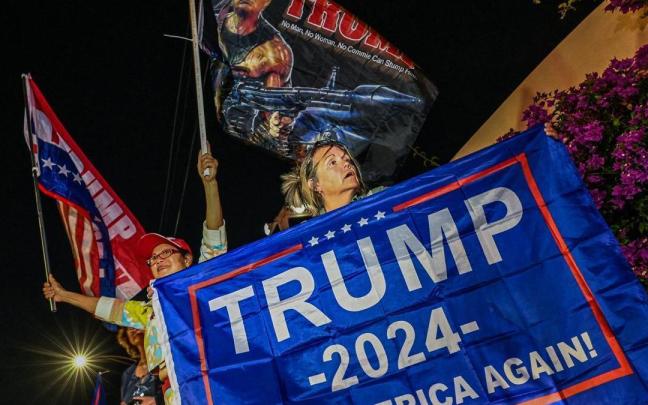 Una seguidora de Trump sujeta una pancarta en apoyo al expresidente ante su mansi&oacute;n de West Palm, Florida.