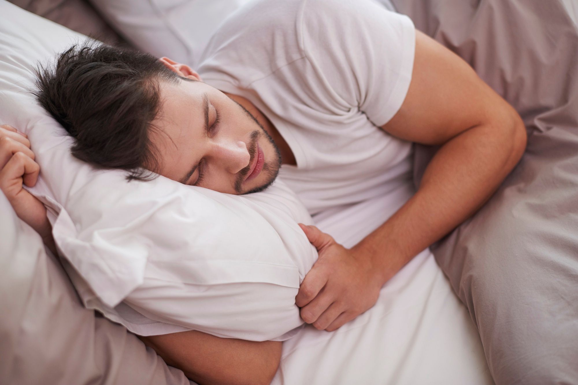 Un joven duerme plácidamente en la cama.