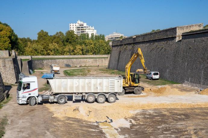 Una grúa carga un camión con la arena pendiente de retirar de los fosos de la Ciudadela un mes después de concluir el concurso de hípica.