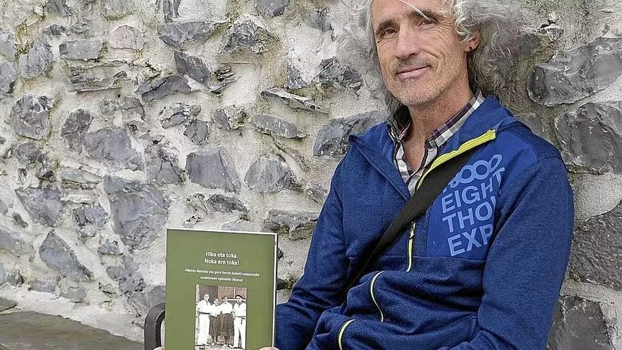 Fernando Oiartzun, en la plaza de Leitza, con el libro 'Hika eta toka. Noera ere toka!'