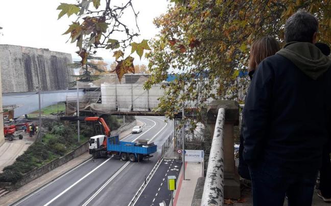 Viandantes observan las labores en la pasarela de Labrit Viandantes observan las labores en la pasarela de Labrit