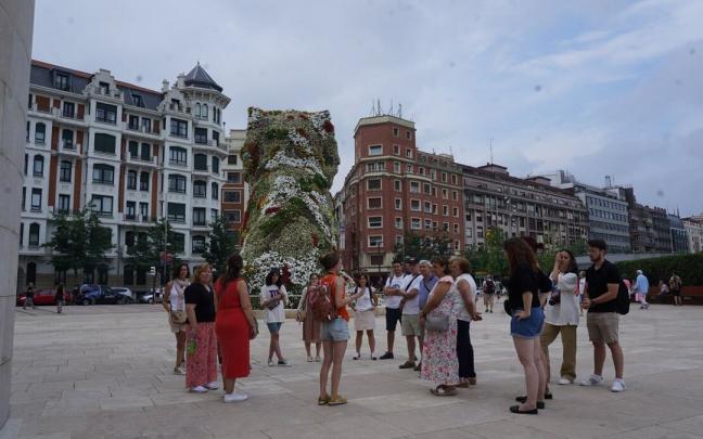 Varios turistas visitan el entorno del museo Guggenheim Varios turistas visitan el entorno del museo Guggenheim