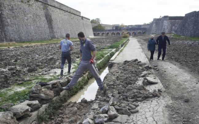 Personas paseando por los fosos de la Ciudadela mientras los trabajadores reparan los destrozos ocasionados una vez retirada la arena y el mobiliario que se utilizó para el concurso de hípica. Personas paseando por los fosos de la Ciudadela mientras los trabajadores reparan los destrozos ocasionados una vez retirada la arena y el mobiliario que se utilizó para el concurso de hípica.