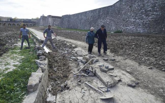 Personas paseando por los fosos de la Ciudadela mientras los trabajadores reparan los destrozos. Personas paseando por los fosos de la Ciudadela mientras los trabajadores reparan los destrozos.