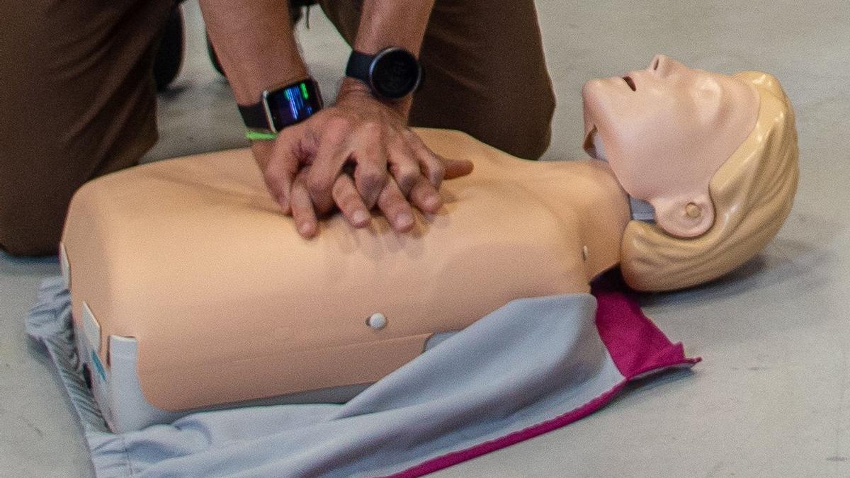 Una persona practica una reanimación cardiopulmonar con un muñeco.