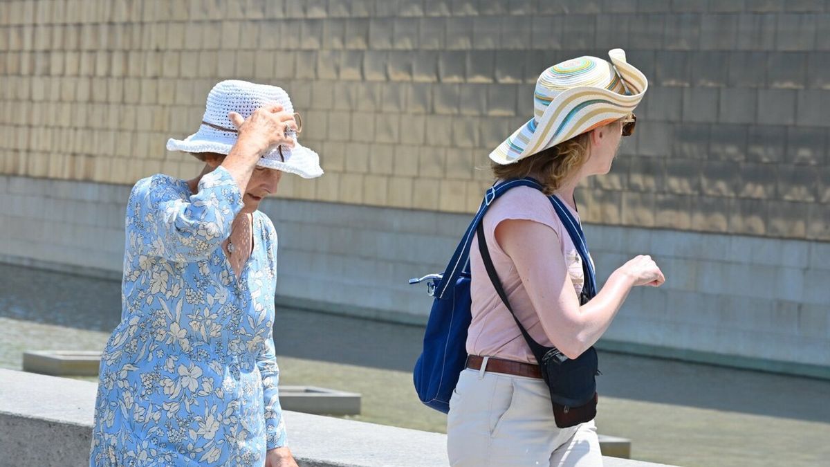 Dos turistas pasean junto al Guggenheim en Bilbao durante la anterior ola de calor