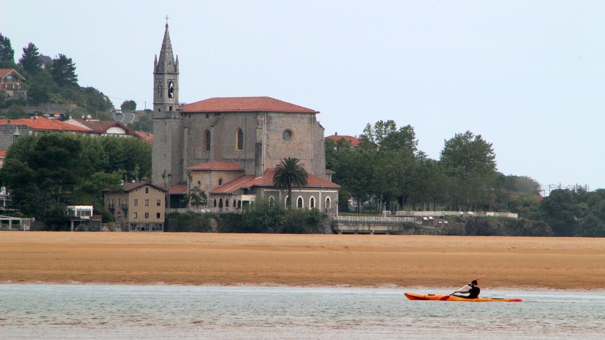 Una persona transita con su kayak por la bocana de la ría, a la atura de Mundaka.