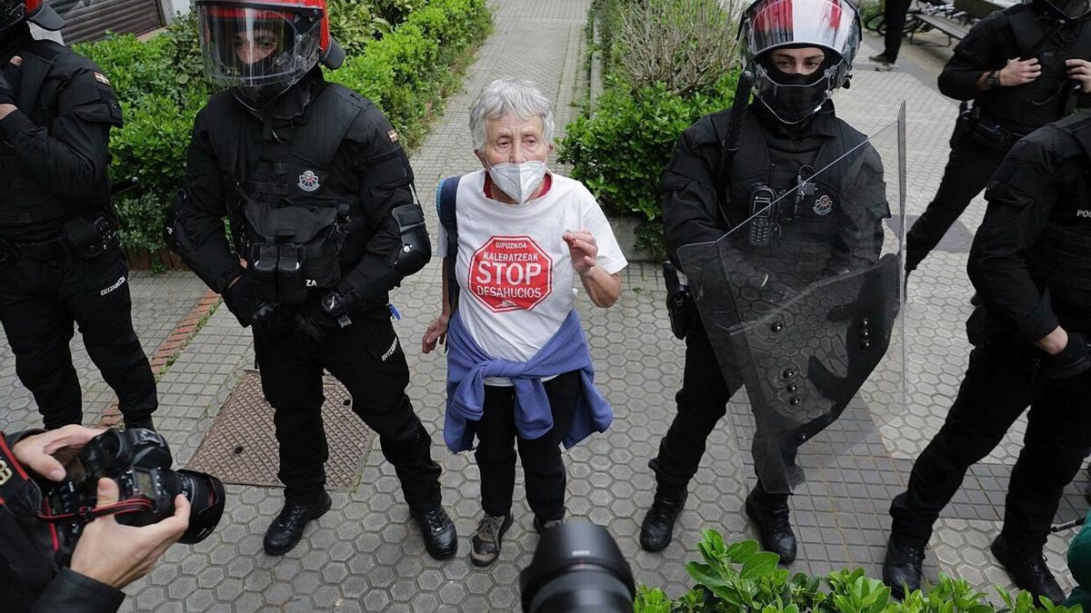 Agentes de la Ertzaintza junto a Rosa García, portavoz de Stop Desahucios en Gipuzkoa