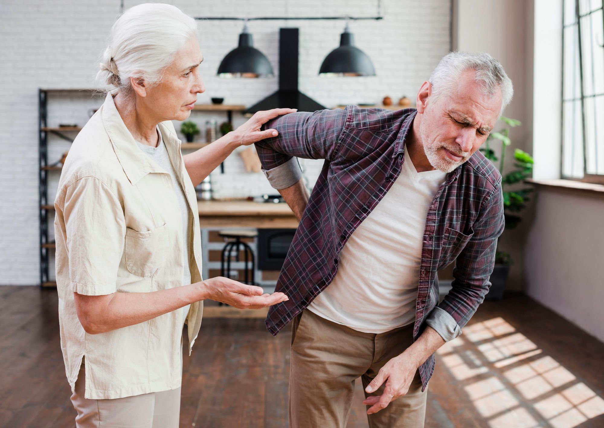 Un hombre, con gesto de dolor, se lleva la mano a la zona lumbar.