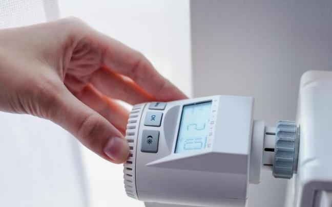 Una persona manejando el contador individual de calefacción central.