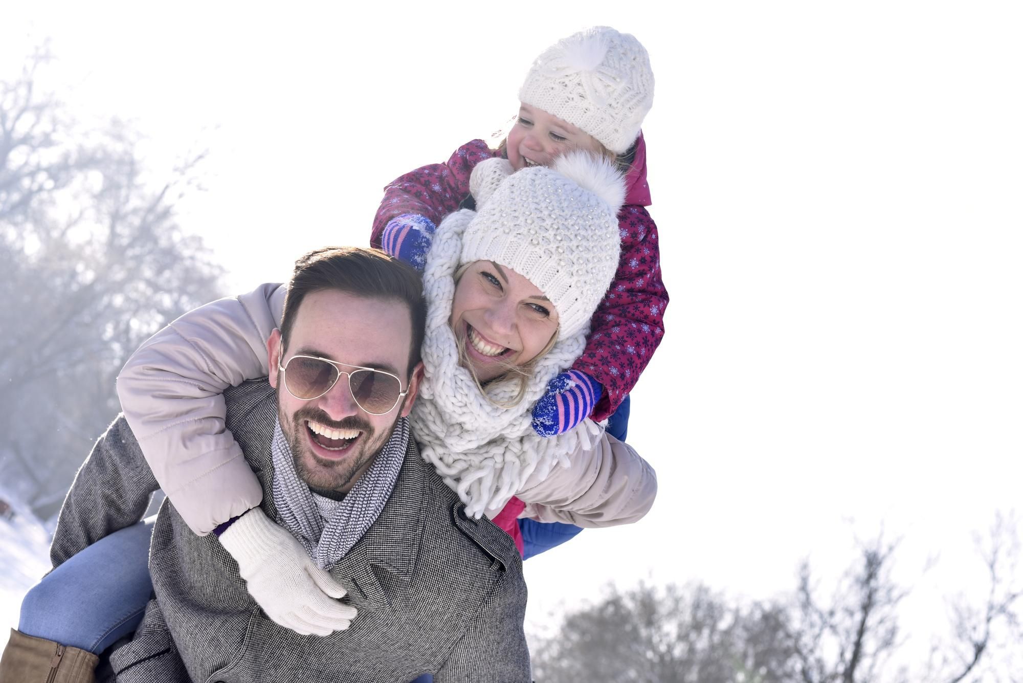 Una familia disfruta de la nieve vestidos con ropa de abrigo.