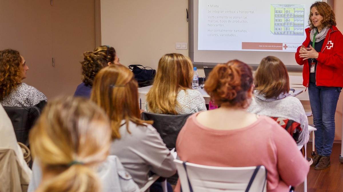 Una técnica de Cruz Roja se dirige a un grupo de mujeres durante un taller de empoderamiento.