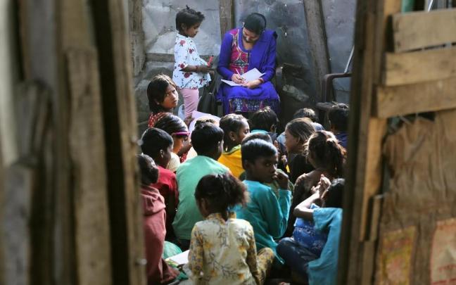 Una profesora da clase a unos niños en la India.