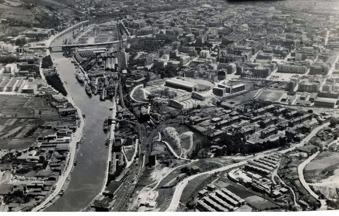 Vista aérea tomada en 1956 donde se observa la zona de Basurto en plena metamorfosis y la actividad portuaria en la ría.