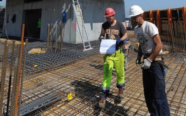 Varios obreros trabajan en la construcci&oacute;n de un edificio.