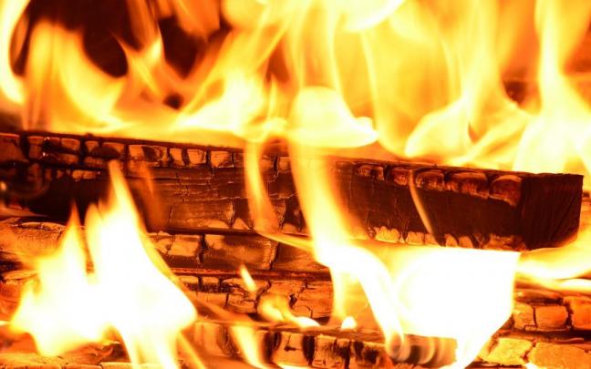 Imagen de detalle de unos troncos ardiendo en una chimenea