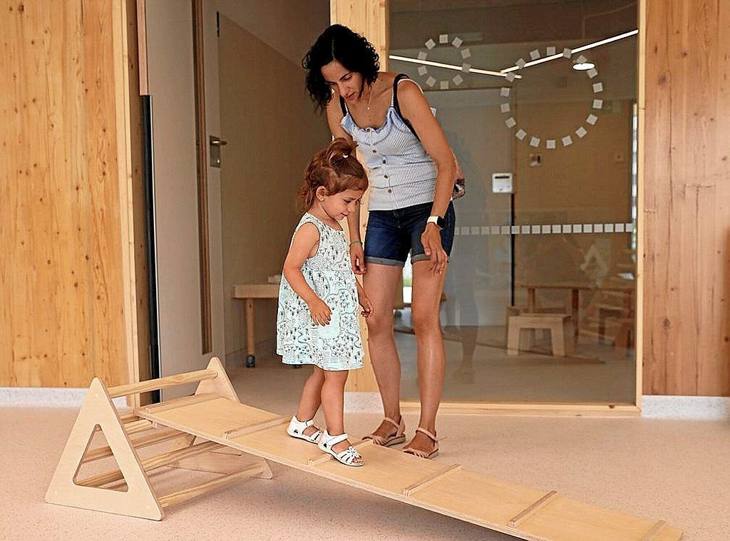 Una madre y su hija en una plataforma de madera en la escuela infantil de Lezkairu.