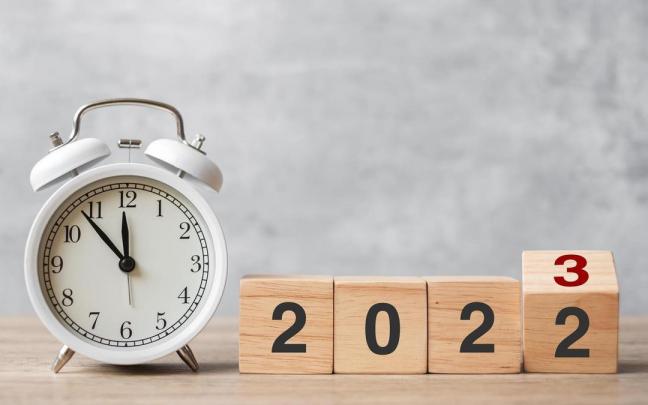 Un reloj a punto de marcar la medianoche y el cambio de a&ntilde;o.