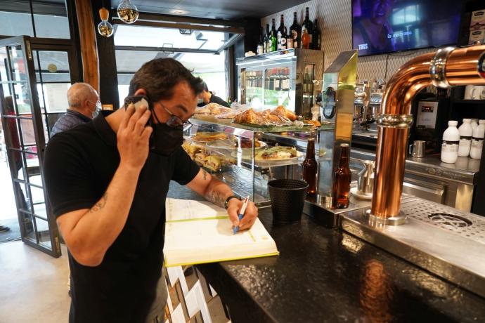 David Bezanilla recoge esta mañana una reserva para el sábado en la barra del restaurante 11 Aldeanos, un local clásico bilbaino en las cenas de grupo.