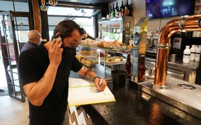 David Bezanilla recoge esta mañana una reserva para el sábado en la barra del restaurante 11 Aldeanos, un local clásico bilbaino en las cenas de grupo.