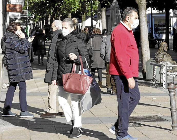 Varias personas caminan por el centro de Gasteiz protegidas con mascarillas. Foto: Pilar Barco