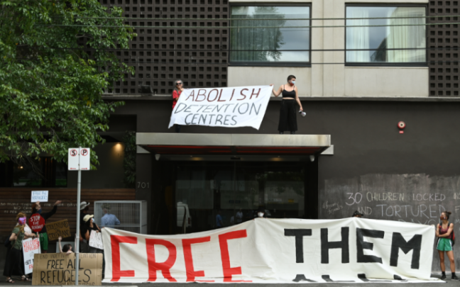 Manifestantes vistos fuera del Park Hotel, donde se cree que se retiene a Novak Djokovic (Melbourne). Manifestantes vistos fuera del Park Hotel, donde se cree que se retiene a Novak Djokovic (Melbourne).