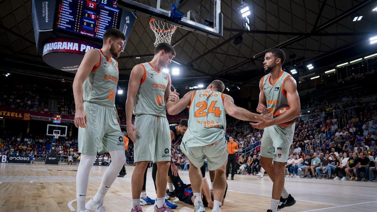 Kotsar y Thompson ayudan a Costello a levantarse durante la derrota sufrida por el Baskonia ante el Barça