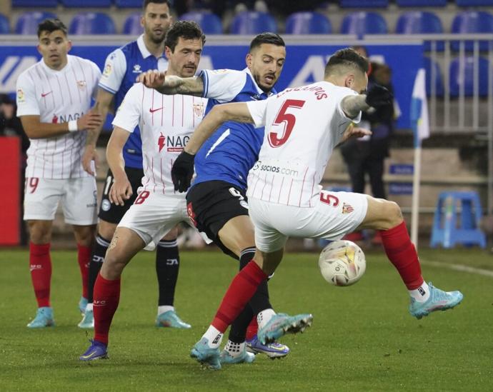 Joselu pelea por un balón con Ocampos en el partido ante el Sevilla