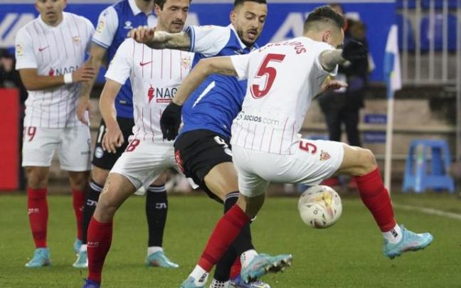 Joselu pelea por un balón con Ocampos en el partido ante el Sevilla