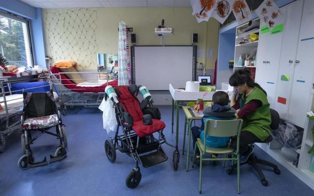 Una profesora atiende aun alumno en el CPEE Andrés Muñoz Garde.