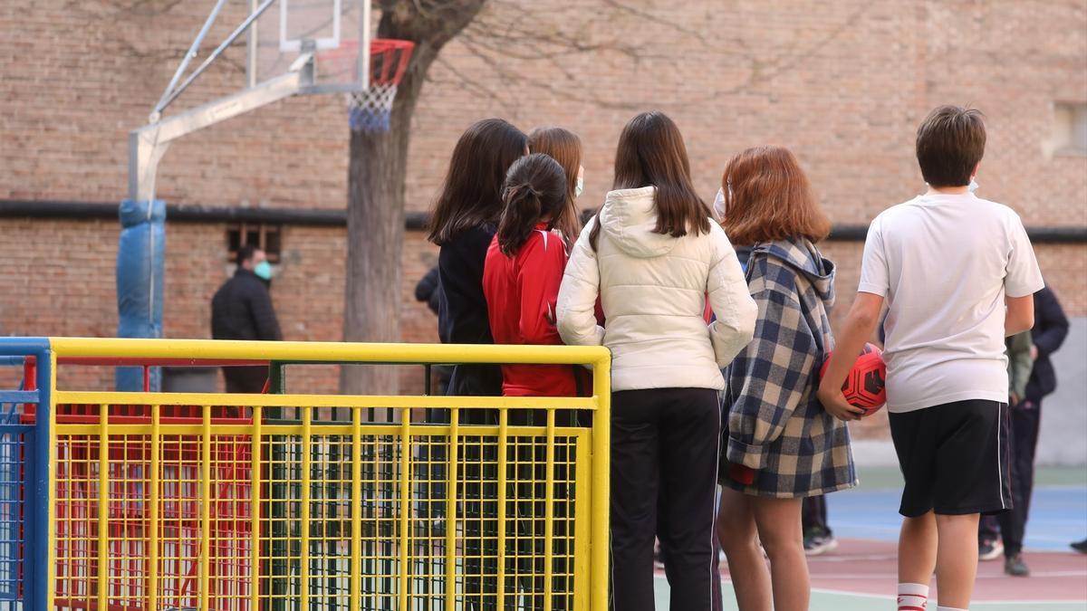 Un grupo de niños en el patio de un colegio.