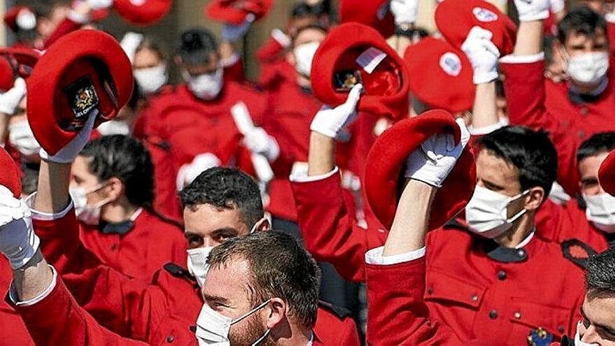 Ertzainas sostienen su txapela roja tras una graduación.