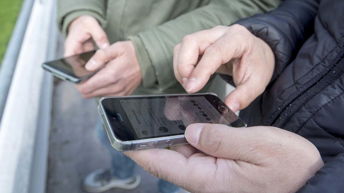 Dos hombres utilizan sendos teléfonos móviles