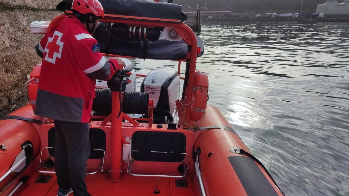 Una embarcación de Cruz Roja Gipuzkoa trata de dispersar el carburante esparcido en el mar tras la caída del camión de la basura