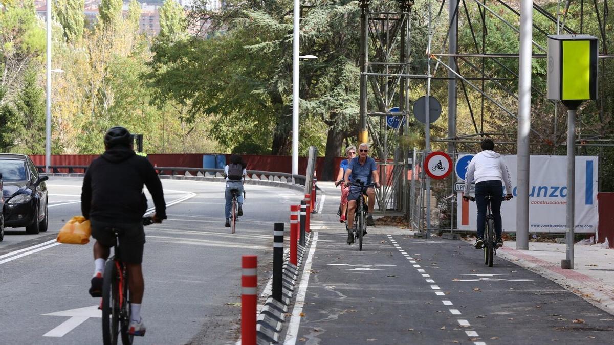 Ciclistas haciendo uso de la calzada y del carril bici en la zona junto a la pasarela, que sigue en obras.