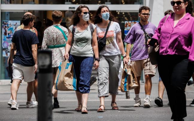 Varias personas pasean por la calle durante la campaña de rebajas de este verano. Varias personas pasean por la calle durante la campaña de rebajas de este verano.