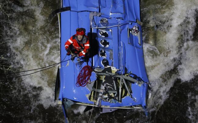 Los bomberos trabajan en el rescate de v&iacute;ctimas del autob&uacute;s que se precipit&oacute; al r&iacute;o L&eacute;rez.