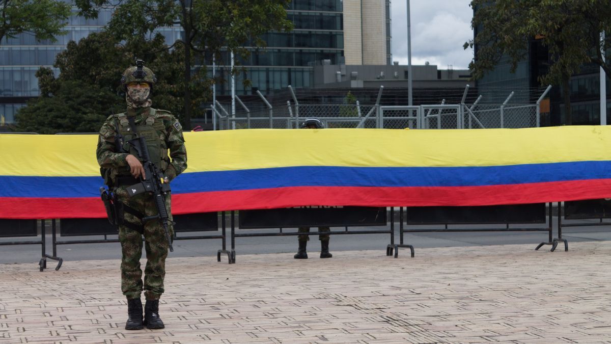 Un militar delante de una bandera de Colombia.