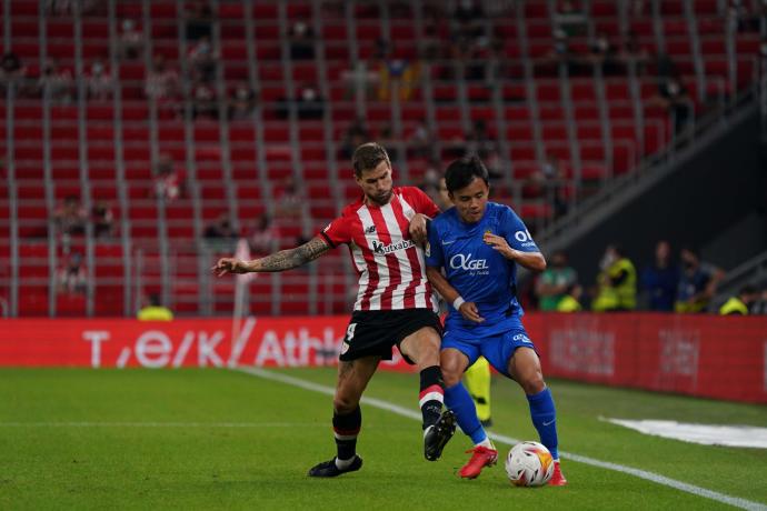 Imagen del partido de ida entre el Athletic y el Mallorca celebrado en San Mamés, con Iñigo Martínez tratando de detener a Take Kubo.