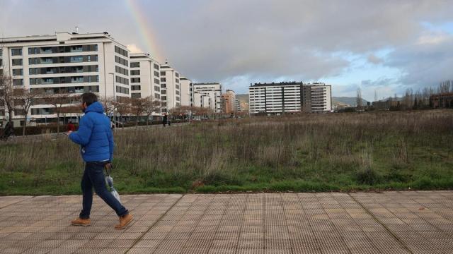 Un vecino pasea por una de las parcelas vacías de Erripagaña, que albergará viviendas y una zona comercial en el futuro.