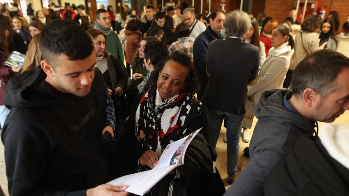 Una familia observa la oferta de titulaciones de la UPV/EHU en la Feria de Orientación Universitaria.