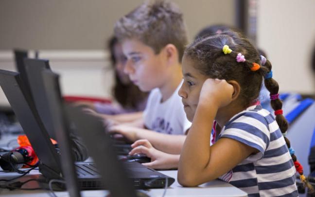Varios niños trabajan con un ordenador portátil. Varios niños trabajan con un ordenador portátil.