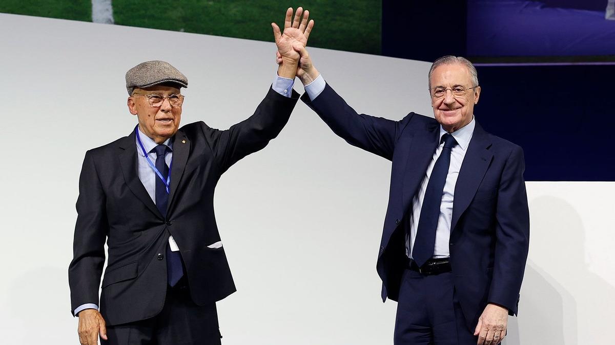 Florentino Pérez levanta la mano de Amancio Amaro tras ser nombrado presidente de Honor del Real Madrid.