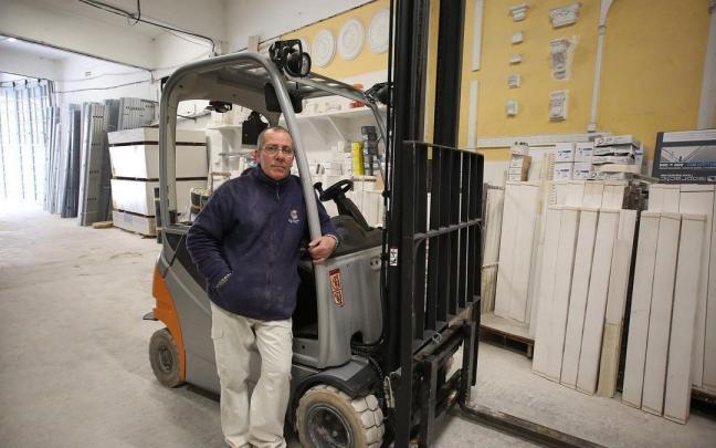 Gracia en 2021, junto a bloques dañados aún con la marca del nivel del agua, en su almacén de escayolas de la calle Joaquín Beunza.