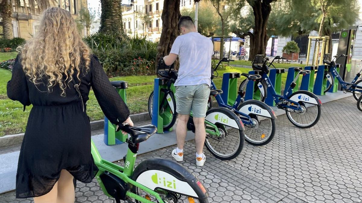 Dos usuarios de Dbizi retiran bicicletas eléctricas del aparcamiento del Ayuntamiento.