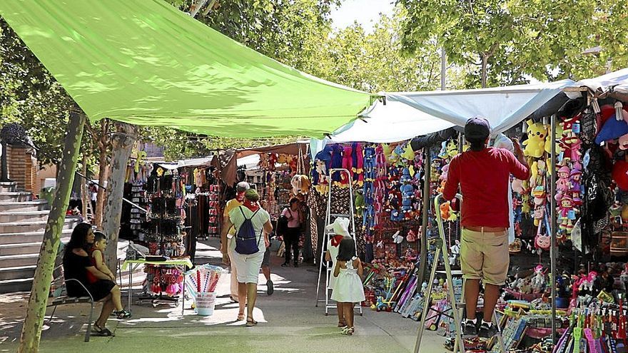 Uno de los vendedores recoloca un toldo en el paseo del Queiles.